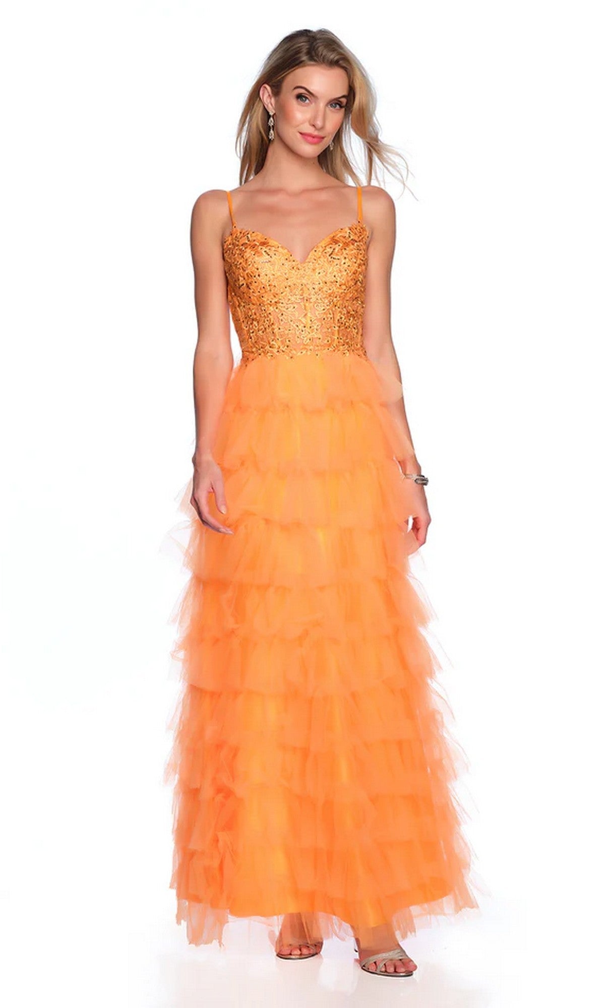 A woman models the Dave and Johnny Long Tiered Prom Dress 11148—an orange floor-length gown with a sequined bodice and long tiered tulle skirt—paired with earrings and sandals, set against a white background.